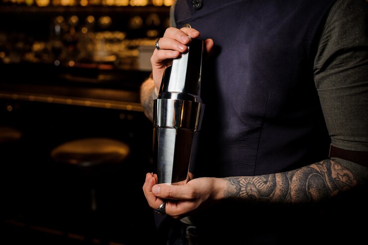 Barista professionista che tiene lo shaker in acciaio