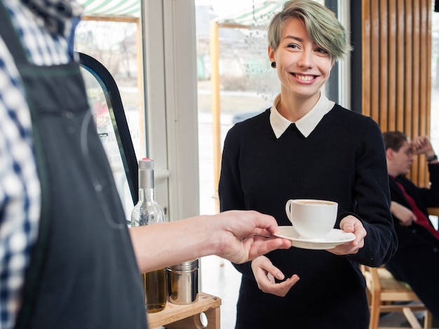 Barista serve tazza cliente hipster ragazza caffetteria