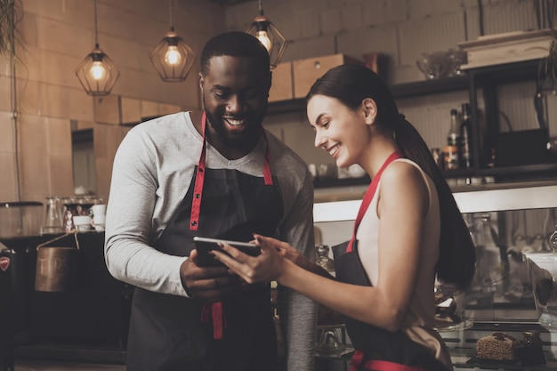 Barista uomo e donna guardando un tablet