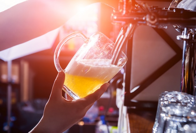 Barista versando birra alla spina ai bicchieri nel bar. Ristorante.