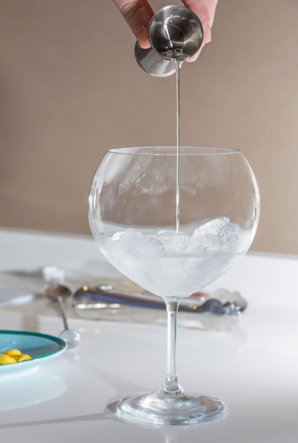 Barman che versa drink per preparare cocktail gin tonic