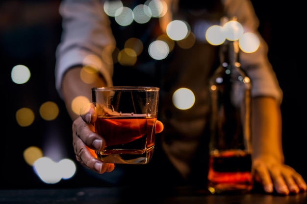 Barman versando whisky bicchiere di whisky bella notte