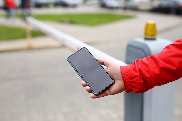 Barra maschio di limite di commutazione dello smartphone della tenuta della mano al primo piano del passaggio dell'iarda