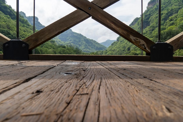 Barranca huentitan guadalajara vecchio pavimento in legno travi in legno e traverse montagne e cavi tesi vegetazione sullo sfondo