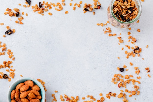 Barretta di cereali muesli con noci, frutta e bacche su un tavolo di pietra bianca. Barretta di muesli. Snack salutare. Vista dall'alto.