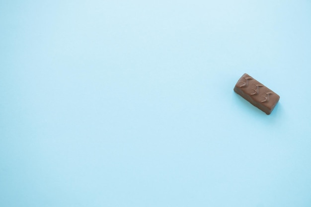 Barretta di cioccolato al cioccolato su sfondo blu