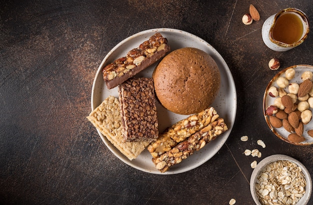 Barrette di cereali ai cereali con noci e bacche sul tavolo scuro Vista dall'alto di snack dolci e salutari