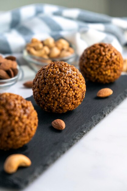 Barrette di cereali fatte in casa a base di anacardi briciole di farina d'avena e noci di mandorle e caramello su tavola di ardesia nera