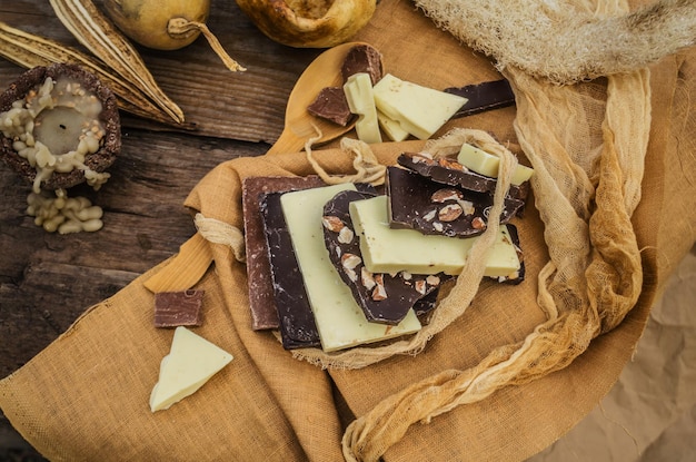 Barrette di cioccolato bianco e latte scuro su fondo di legno