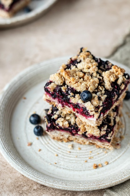 Barrette di crumble di mirtilli fatte in casa su un piatto per colazione con tovagliolo da vicino Spuntino scolastico sano