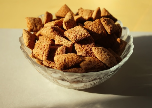 Barrette di muesli in una tazza trasparente alla luce del sole