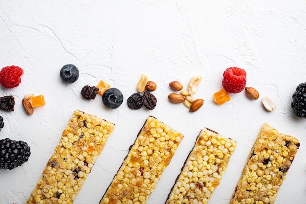 Barrette per la colazione Superfood con noci di avena e bacche fresche, vista dall'alto con spazio copia, su sfondo bianco