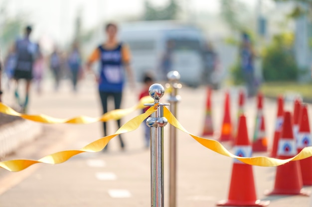 Barricata di lusso in acciaio inossidabile con nastro di corda gialla su strada nell'evento di maratona al punto di arrivo.
