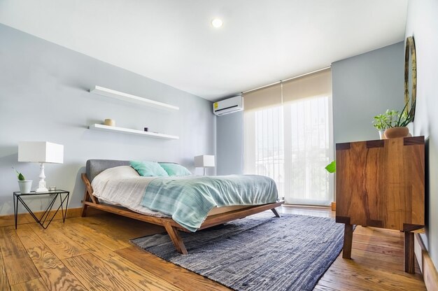 Base letto camera da letto con stuoia sul pavimento vaso di terracotta sullo sfondo credenza in legno e specchio