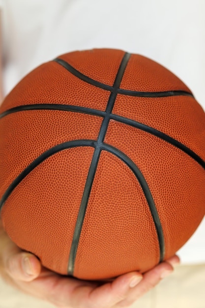 Basket rosso nelle mani di un primo piano su sfondo bianco