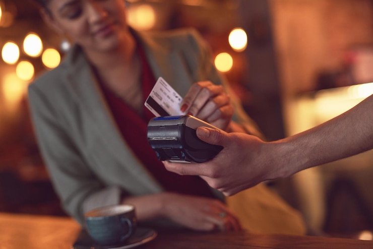 Foto basta scorrere primo piano di una giovane donna che fa scorrere la carta di credito per effettuare un pagamento in un bar