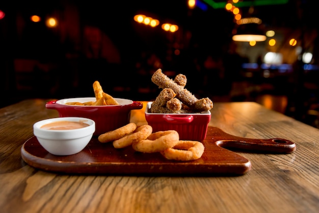 Bastoncini, cipolle fritte e pomodori fritti con salsa