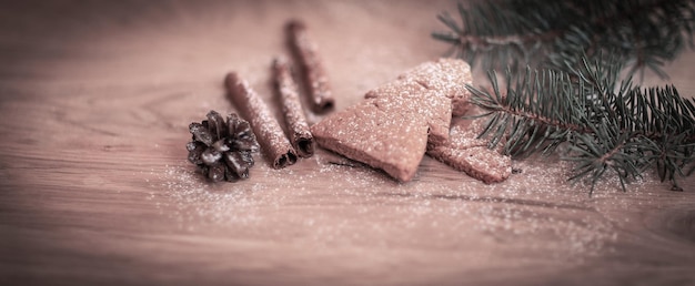 Bastoncini di cannella biscotti e ramo di albero di Natale ma il tabl