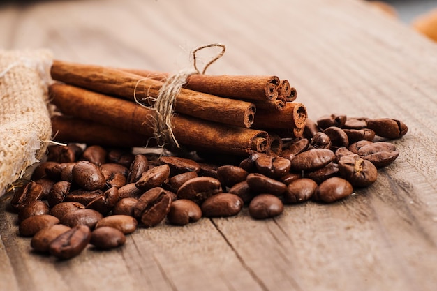 Bastoncini di cannella marroni crudi organici sul vecchio tronco di legno del ceppo della tavola di legno all'aperto