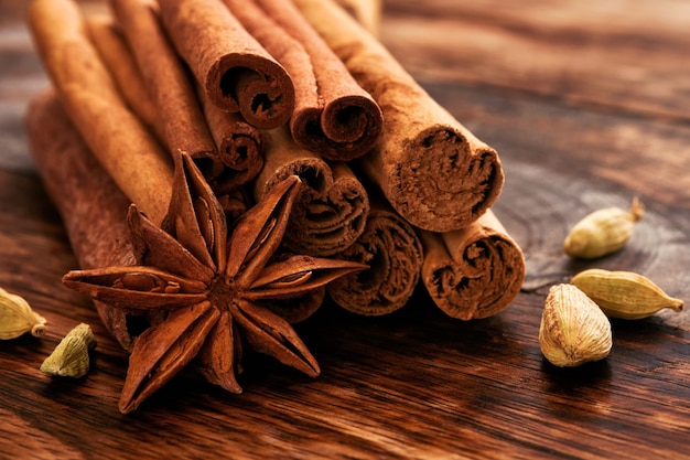 Bastoncini di cannella, stelle di anice e cardamomo su un tavolo di legno. Set di spezie per vin brulé, torta di Natale, biscotti. Messa a fuoco selettiva. avvicinamento