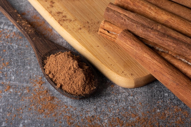 Bastoncini di cannella su uno sfondo di legno. Spezie alla cannella in un cucchiaio e una ciotola. Cannella di Ceylon.