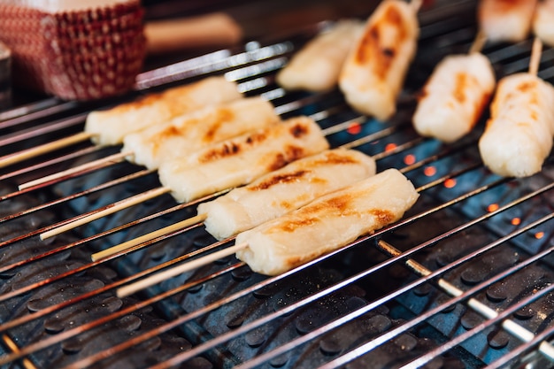 Bastoncini di formaggio alla griglia sulla stufa a gas, cibo di strada a Ximending a Taiwan, Taipei.