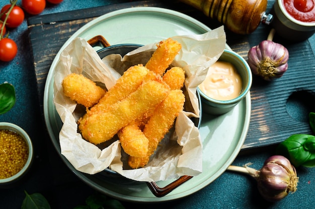 Bastoncini di formaggio fritti con salsa di hamburger Primo piano su un piatto Su uno sfondo di pietra nera