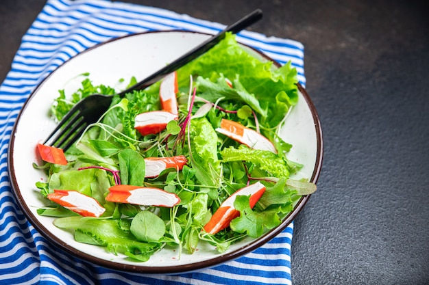 Bastoncini di granchio insalata di foglie di lattuga verde mescolare pasto fresco snack sul tavolo spazio copia sfondo alimentare