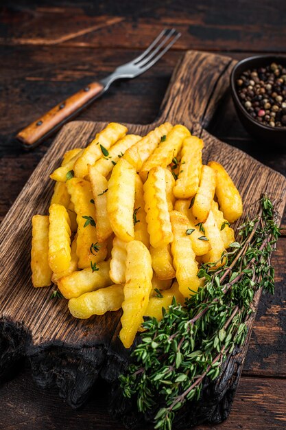 Bastoncini di patate fritte Crinkle al forno o patatine fritte su una tavola di legno