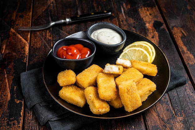 Bastoncini di pesce fritto Dita con salsa in un piatto Fondo in legno Vista dall'alto