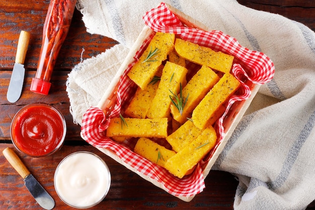 Bastoncini di polenta fritta nel cestino sopra la tavola di legno rustica