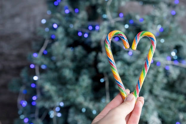 Bastoncini di zucchero a forma di cuore. albero di Natale. mezzanotte. Stile retrò Buon Natale o felice anno nuovo concept.Breeting card
