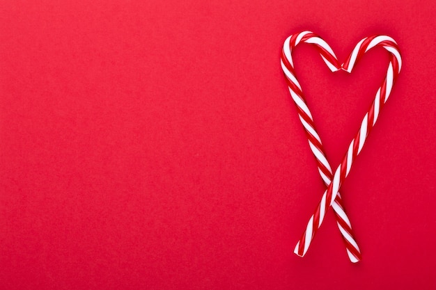 Bastoncini di zucchero di Natale, bastone e decorazioni su sfondo colorato. Sweet Christmas Card - Bastoncini Di Zucchero Con Nastro - Immagine.