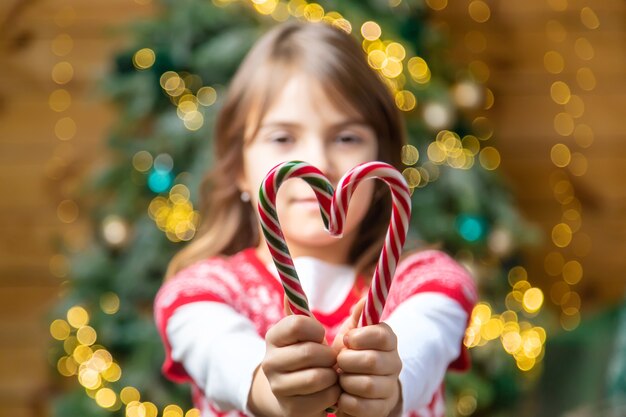 Bastoncini di zucchero di Natale nelle mani di un bambino. Messa a fuoco selettiva. Vacanza.