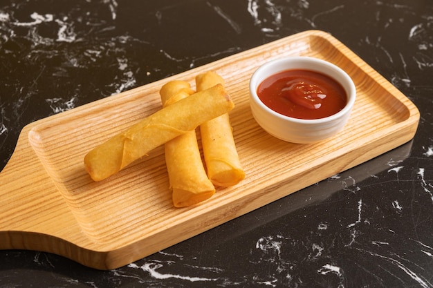 Bastone di formaggio fritto nel grasso bollente sul piatto di legno
