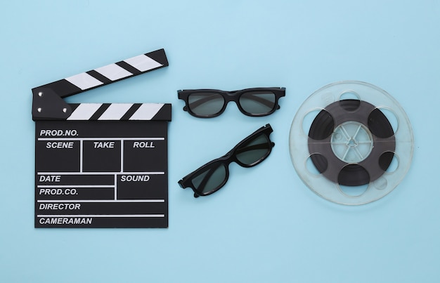 Batacchio di film, bobina di film e occhiali 3D su blu. Industria dell'intrattenimento. Cinema