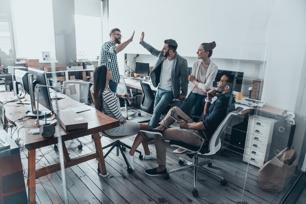 Batti il cinque per il successo! Riunione del team aziendale in ufficio