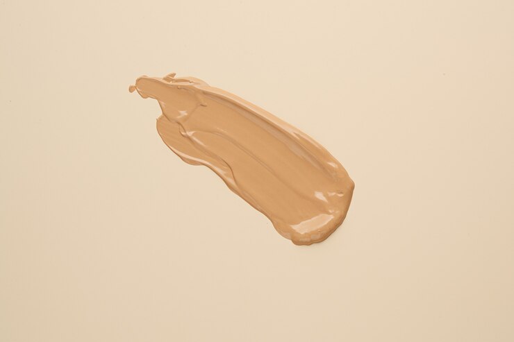 BB, fondotinta CC crema sfumino tonale sulla superficie beige nuda