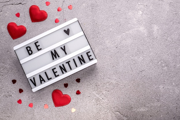 Be my Valentine light box con cuori rossi su sfondo di cemento con spazio di copia