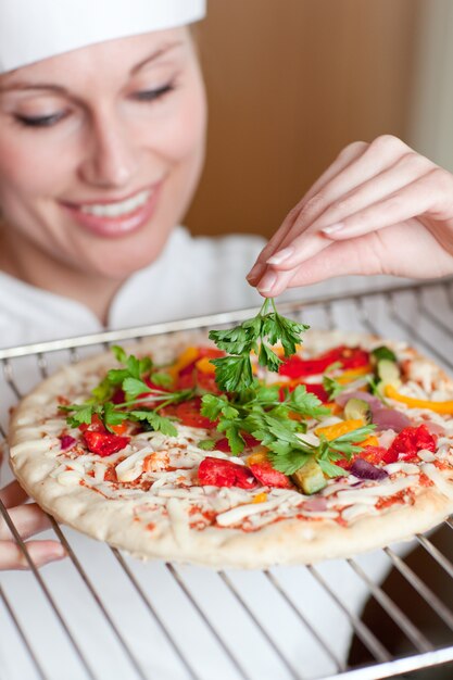 Beaautiful chef femminile prepara una pizza