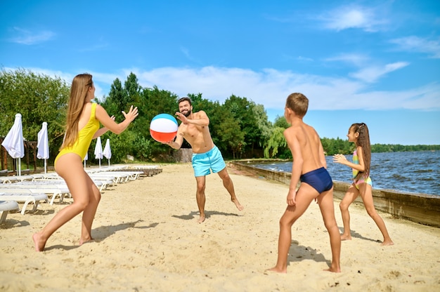 Beach volley. Una famiglia che gioca a beach volley e si sente felice