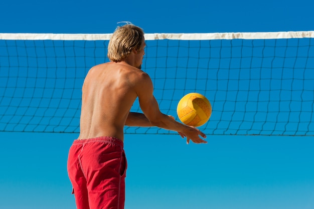 Beach volley - uomo che serve la palla