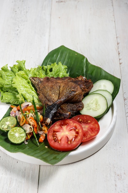 Bebek Goreng sambal matah anatra fritta servita con sambal e verdure fresche