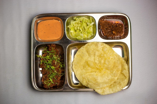 Beef Chaap con Lucchi con salsa di chuntney e dip di peperoncino servito in un piatto di thali isolato sullo sfondo vista superiore del menu set di cibo bangladeshi