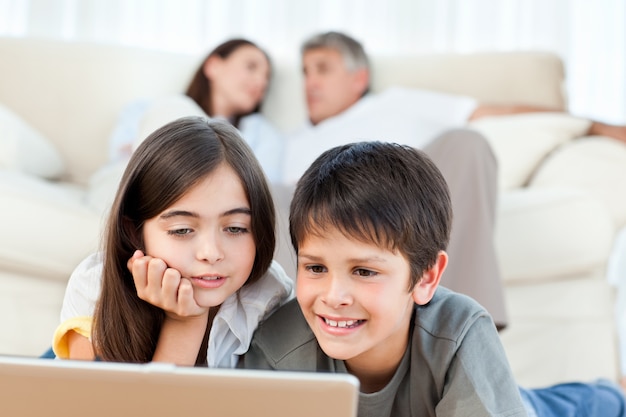 Bei bambini che guardano un film sul loro portatile a casa