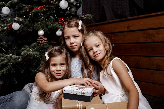 Bei bambini che ridono felici con l'albero di Natale