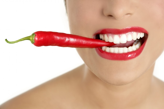 Bei denti della donna che mangiano peperone