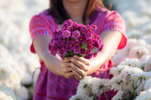 Bei fiori in mano della donna nel giardino floreale