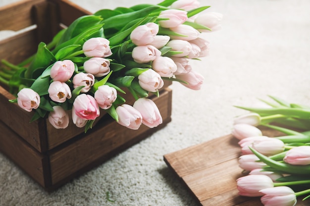 Bei fiori rosa del tulipano nella scatola di legno