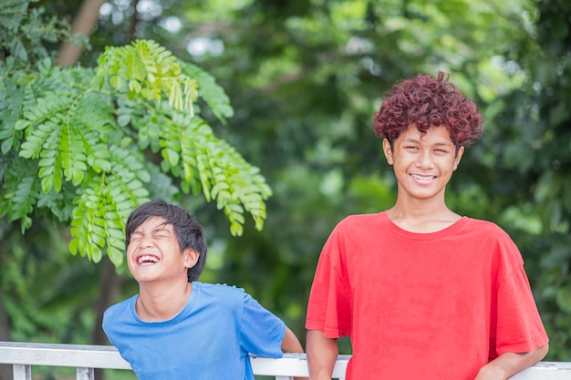 Bei giovani fratelli adolescenti asiatici che sorridono, ridono e si divertono insieme